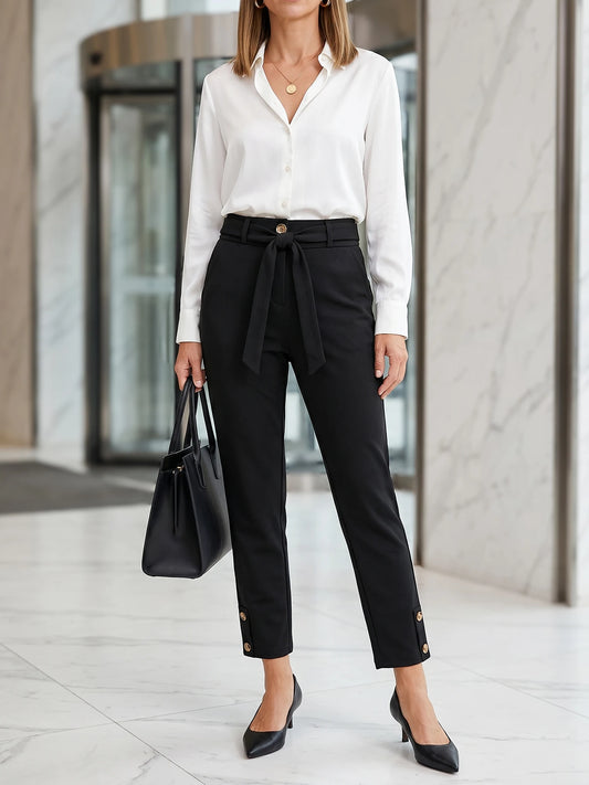 Women's elegant high-waisted formal business trousers with chic button details and cropped length.